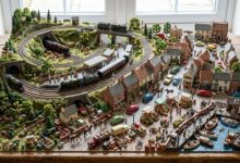 Model train collection showing different scales, locomotives, track layouts, accessories, and detailed miniature railway models